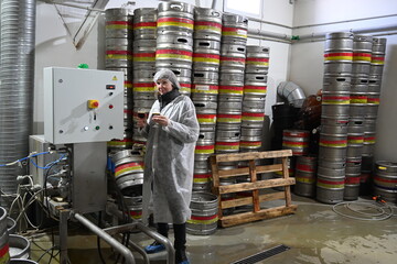 Photo of a warehouse worker on the background of barrels