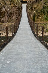 Obraz premium Gifu,Japan - April 22, 2022: Deai bridge on Sho river, a suspension bridge connecting the Bus Parking lot and the UNESCO town of Shirakawa-Go 