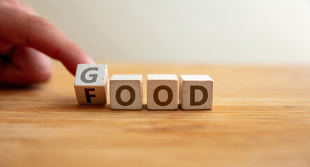 Good food concept. Hand flips letter on wooden cube changing the word food to good.