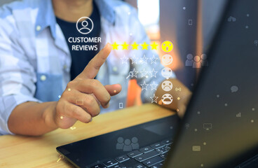 A man in plaid shirt on the working desktop is pointing at highest and yellow five star or 5 star satisfy evaluation score to the customer reviews.