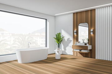 Light bathroom interior with tub, sink and deck, panoramic window