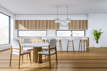 Modern kitchen interior with table and seats, island and panoramic window