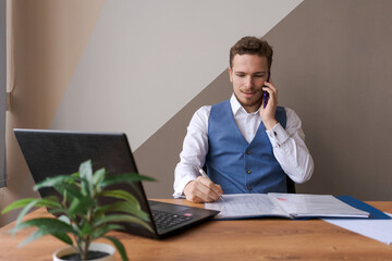 Portrait successful businessman with beard using smartphone and working on documents in office, success man in office interior with mobile phone and contract on desk. Busy caucasian worker