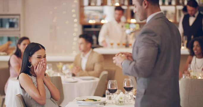 A great ending to a perfect dinner date. 4k video footage of a man proposing to his girlfriend while on a date at a restaurant.