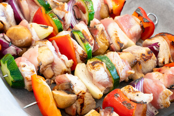 Lightly roasted turkey shish kebab on metal skewers, with lots of colorful veggies, ready for preparation. Delicious, light, great looking food. Getting ready for barbecue.
