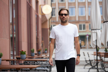 Fototapeta na wymiar White blank t-shirt on a hipster handsome male model with space for your logo or design in casual urban style