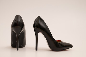 Elegant expensive black high heel women shoes on white background - fetish female weapon