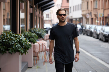 Black blank t-shirt on a hipster handsome male model with space for your logo or design in casual urban style