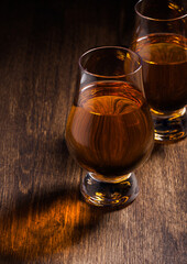 Single malt scotch whiskey in glencairn glasses on wooden background