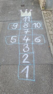 Sidewalk chalk game on asphalt pavement in the neighborhood.