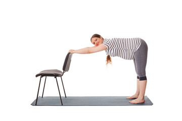Pregnancy yoga exercise - pregnant woman doing yoga asana Uttanasana Standing Forward Fold Pose...