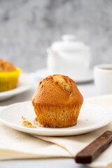 Homemade muffin with colorful paper cups, in a plate served with cup of tea
