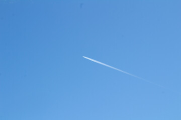 Minimalistischer Kondensstreifen am wolkenlosen Himmel