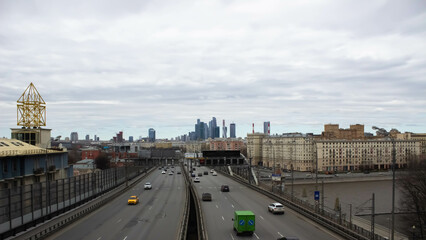 Fototapeta na wymiar Beautiful old buildings. Overcast weather. Business center Moscow city in the distance. Highway with cars