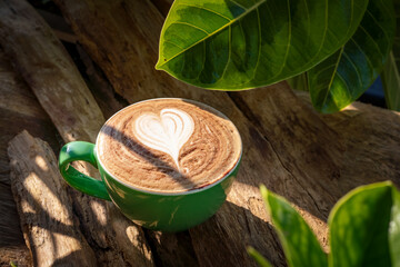 Hot Cup of Coffee on wooden in garden at the morning sun