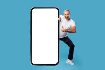 Man peeping out big white empty smartphone screen, mock-up
