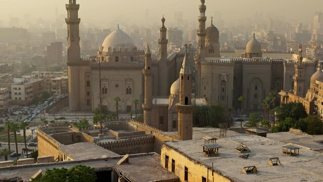 Tilt shot of Mosque of Sultan Hassan, Cairo, Egypt at sunset. One of the best views of the city of Cairo - houses, mosques and roads with vehicles.