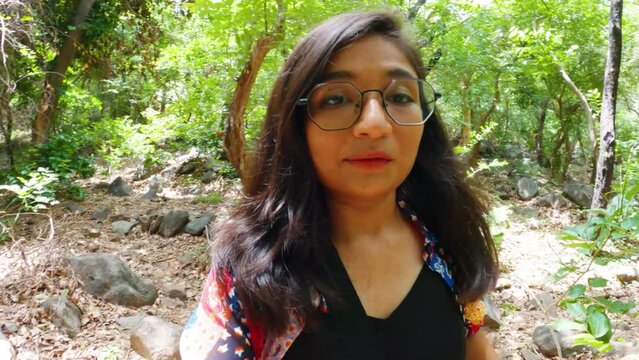 Young Indian Travel Woman Vlogger vlogging in forest of Junagadh with an action camera.  Social media influencer on location in Asia.