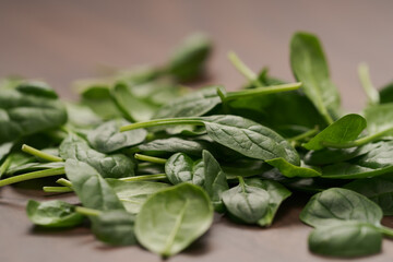 Fresh spinach leaves on walnut wood table