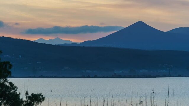 Sunrise over nature reserve Katafigio Agrias Zois Limni Ntivari with flamingo birds at the lake und mountains in background, Peloponnese, Greece