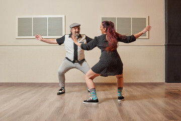 Mature couple of Lindy Hop dancers in a ballroom