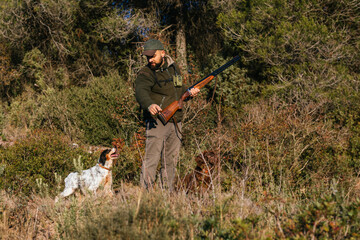 Male hunter hunting with his hunting dog outdoors.
