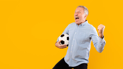 Mature man screaming holding soccer ball on yellow background