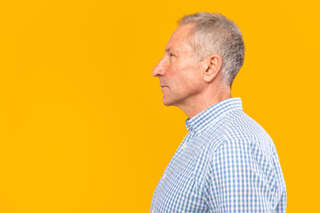 Serious mature man posing looking aside at studio