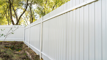 Outdoor garden fence building, new installed base frame with supports for a new metal fence in...
