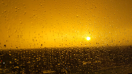 ガラス越しの雨と夕日