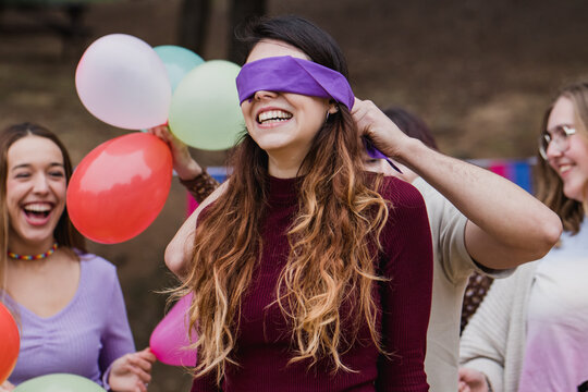 Surprise on birthday party , group of friends playing with blindfold on eyes and laughing
