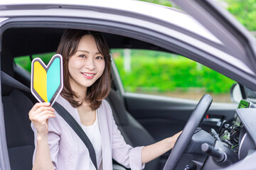 A young female driver with a beginner's mark - obrazy, fototapety, plakaty
