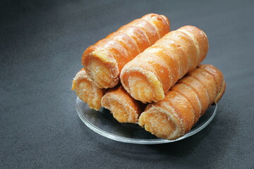 cannoncini su sfondo nero, italian cream sweets on a white background