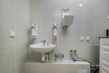 metal water tap with sink and faucet to turn on and regulate cold or hot water in expensive bathroom.