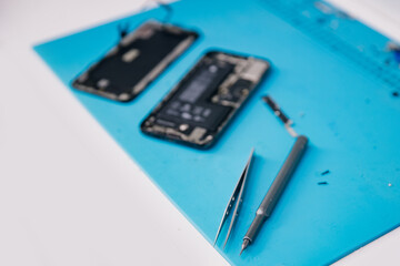 Closeup screwdriver tool repair modern mobile phone, master disassembles case to replace broken...
