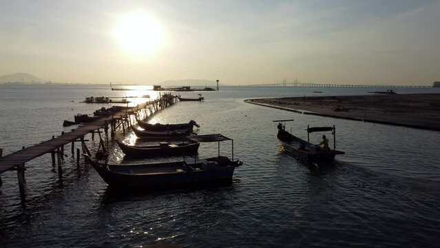 Silhouette fish boat move near jetty in morning