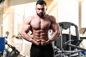 Fototapeta na wymiar Handsome Body Builder Making Most Muscular Pose