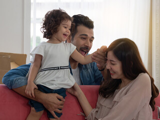 Happy family, father, mother and cute little toddler girl spending quality time, bonding time while moving house.