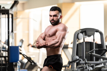 Naklejka na ściany i meble Muscled Male Model Posing In The Gym
