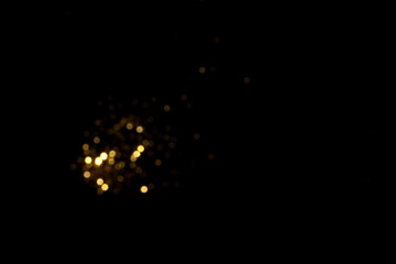 Golden blurred bokeh lights on black background. Glitter sparkle stars for celebrate. Overlay for...