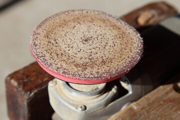 Grinder tool machine with used non-perforated grinding disk on the wooden workbench stand. Equipment for DIY woodworking sanding