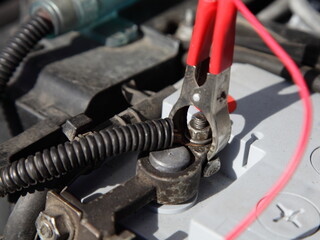 Positive pin with red terminal cleat on car battery - fast accumulator charge in car