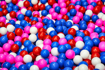 Background texture of multi-colored plastic balls on playground. Dry pool filler.