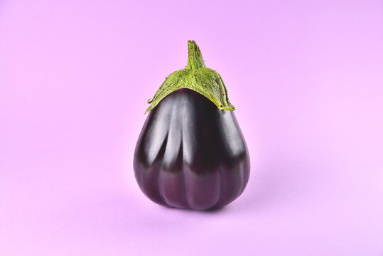 Eggplant on a purple background, fresh juicy vegetable on a colored background, selective focus, soft focus