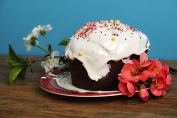 Traditional Easter cake with sugar icing and eggs on a wooden table.