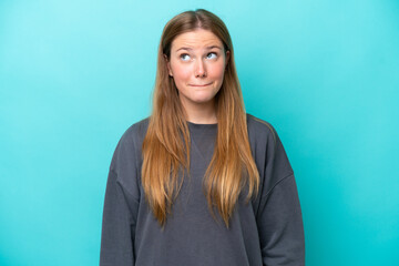 Young caucasian woman isolated on blue background having doubts while looking up