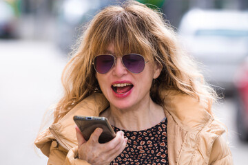 woman sending audio or voice message on the phone in the city