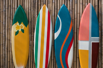colorful paint surfboards on bamboo wooden wall