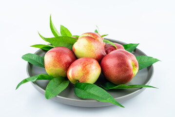A plate of fresh nectarines on a white background