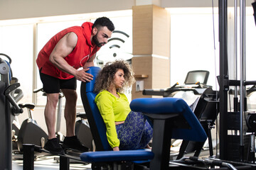 Fototapeta na wymiar Gym Coach Helping Woman On Legs